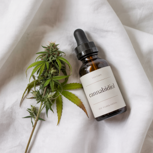 A winding road leading to a CBD oil bottle set in a nature-inspired landscape
