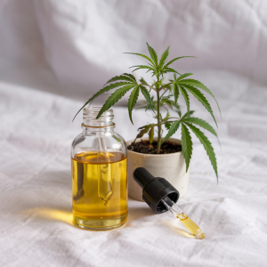 A dropper releasing organic CBD oil against a natural, textured backdrop 